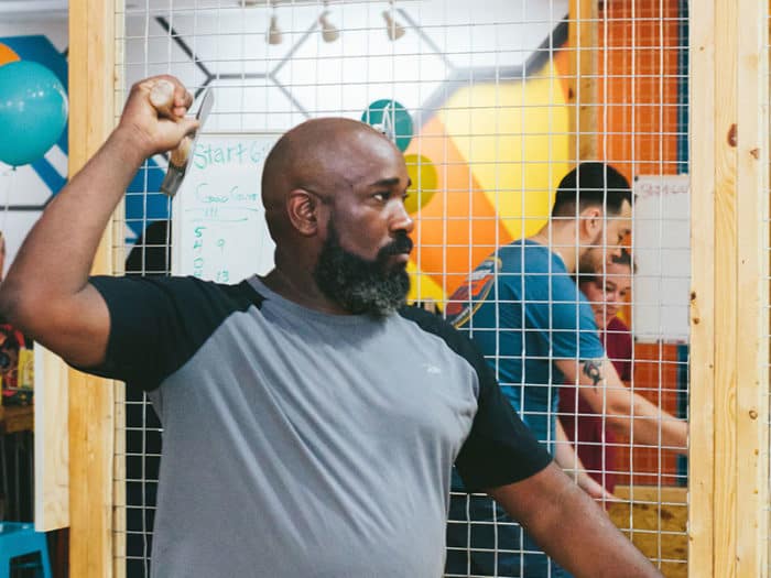 man throwing axe at an indoor target