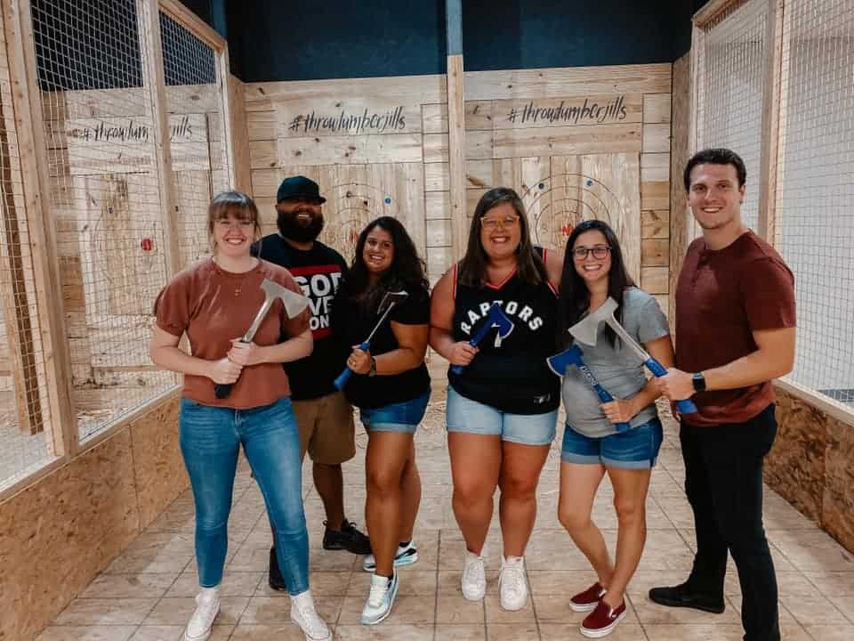 Image of 6 individuals holding axes while posing for a picture taken at Throw Lumber Jills' axe-throwing lanes - www.throwlumberjills.com